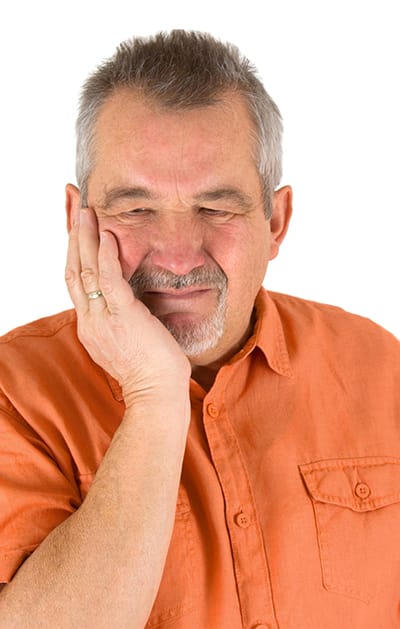 Man holding his cheek with unbearable pain from a toothache.