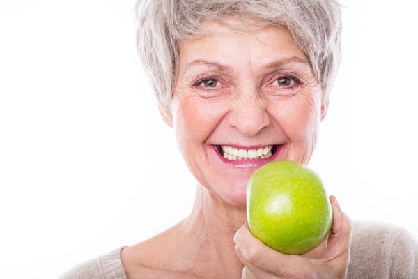 Woman smiling confidentially wearing her new dentures.