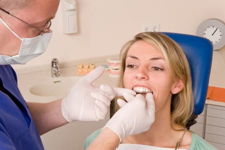Dentist improving a woman's teeth using Invisalign treatment.
