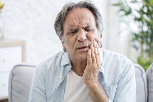 man holding jaw in pain